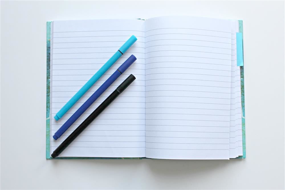  Notebook with Pencils lying on top