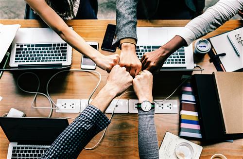 fist bumping over computers 